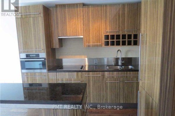 Modern kitchen with wood grain cabinets, stainless steel appliances, and granite countertops. - 1608 - 80 John Street, Toronto