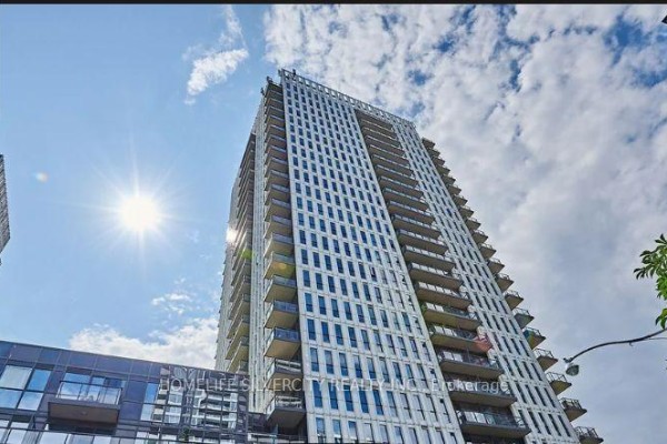 A tall, modern apartment building with numerous balconies and a white facade under a sunny sky. - 1609 - 170 Sumach Street, Toronto