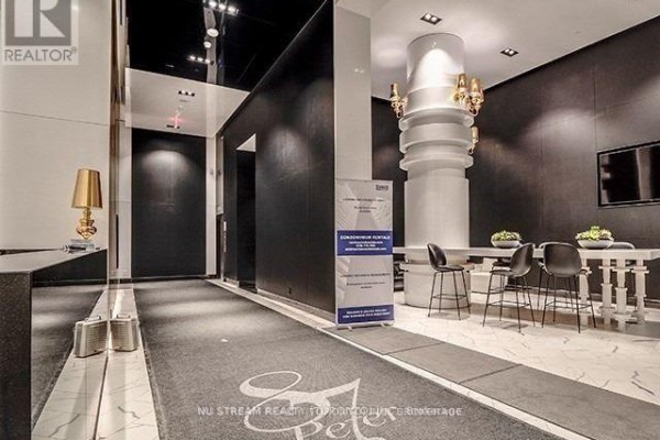 Building lobby with marble floors, black walls, modern lighting, and seating area. - 1609 - 87 Peter Street, Toronto