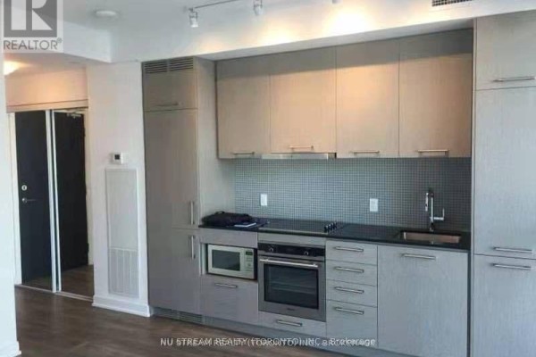 Kitchen area with grey cabinets, black countertop, stainless steel appliances, and backsplash. - 1609 - 87 Peter Street, Toronto