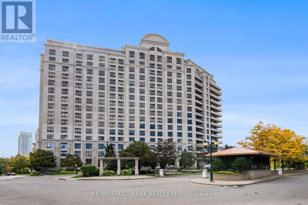 Exterior view of a large, modern apartment building with a blue sky. - 1609 - 9235 Jane Street, Vaughan
