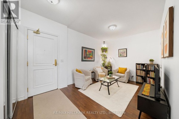 Living room with white furniture, yellow accent pillows, and a large mirror closet. - 1609 - 9235 Jane Street, Vaughan