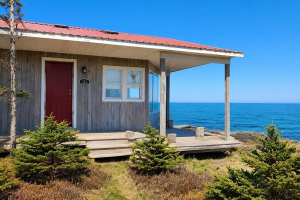 View of the ocean and rocky shore from a covered deck with wooden railings. - 161 Culloden Wharf Branch, Culloden