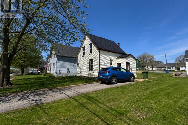 Exterior view of a white house with light blue siding on a sunny day. - 161 Hanover Street, Summerside
