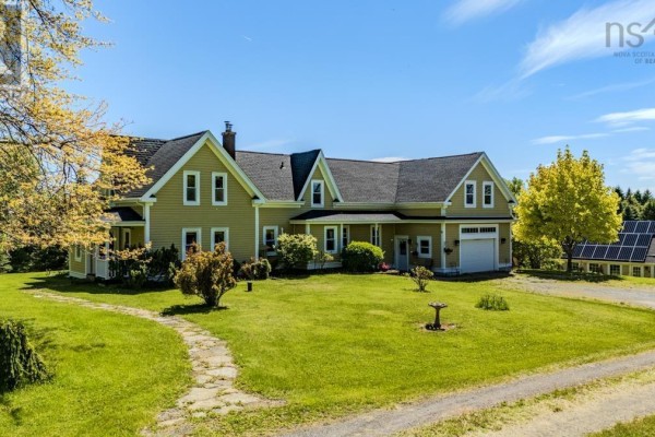 Living room with hardwood floors, leather sofas, wood stove, and doorway to dining area. - 161 Highway 311 Loop, Balfron