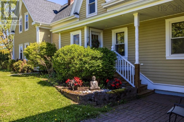 Large kitchen with wood floors, two islands, white cabinets, stainless steel refrigerator, and pendant lights. - 161 Highway 311 Loop, Balfron