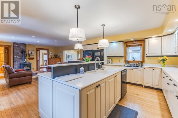 Kitchen with white cabinets, quartz countertops, stainless steel appliances, and sink with faucet. - 161 Highway 311 Loop, Balfron