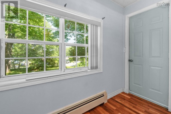 Front of a small, light grey house with a blue door, surrounded by a green lawn and trees. - 161 Lakeview Road, Lakeview