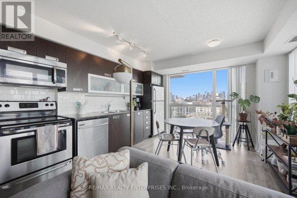 Living and dining area with a balcony, featuring floor-to-ceiling windows. - 1610 - 100 Western Battery Road, Toronto