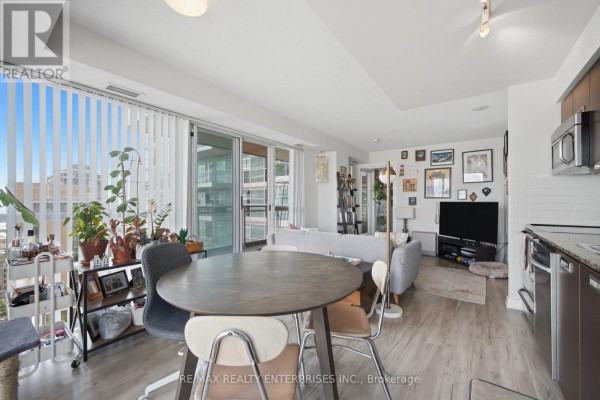 Living room with grey sectional sofa, coffee table, and television on stand. - 1610 - 100 Western Battery Road, Toronto