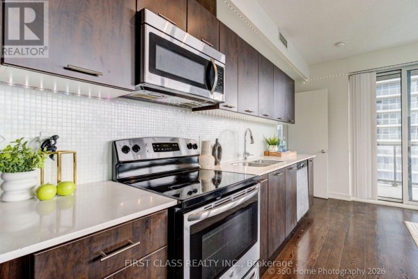 Cozy dining space with a table, chairs, and large windows overlooking the city - 1610 - 20 Bruyeres Mews, Toronto