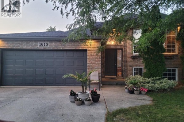 Exterior view of the house showing the brick facade and green lawn. - 1610 Chornoby Crescent, Tecumseh