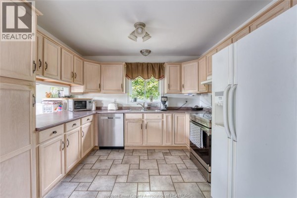 Kitchen with light wood cabinets, white refrigerator, and stainless steel appliances - 1610 Chornoby Crescent Tecumseh