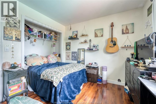 Bedroom with bed, hanging guitar, and dresser - 1610 Chornoby Crescent Tecumseh