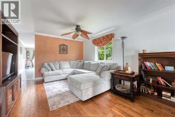Living and dining room with hardwood floors, wood furniture, and textured walls. - 1610 Chornoby Crescent, Tecumseh