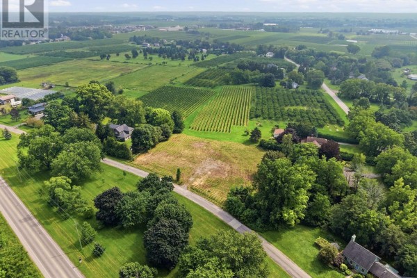 Overhead view of a rectangular vacant lot outlined in red, surrounded by greenery and homes. - 1611 Lakeshore Road, Niagara On The Lake