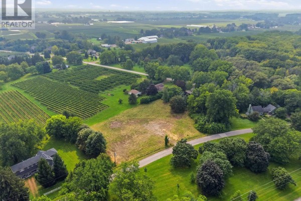 Aerial drone shot showing a cleared building lot with views of surrounding vineyards and countryside. - 1611 Lakeshore Road, Niagara On The Lake
