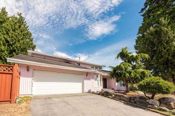 Side view of a pink house with white trim and landscaping. - 16111 10 Avenue, Surrey
