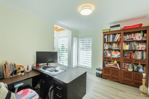 Another view of the office with a corner desk and bookshelf. - 16111 10 Avenue, Surrey