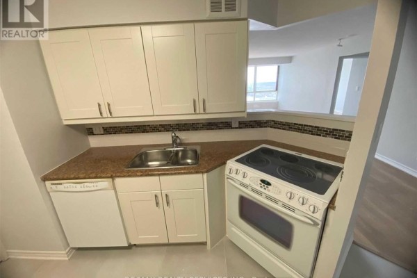 Kitchenette with white cabinets, granite countertops, stainless steel sink, and white stove next to window. - 1612 - 3605 Kariya Drive, Mississauga