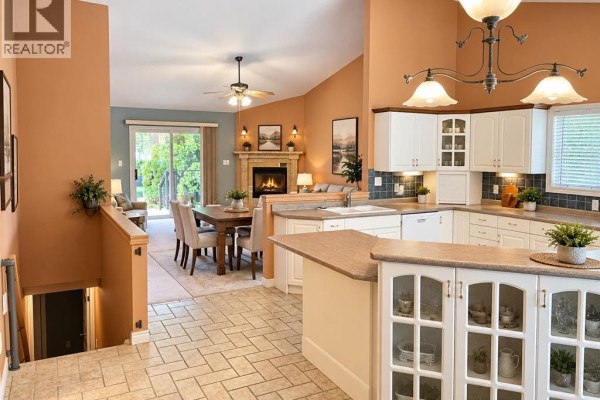 Kitchen with white cabinets and a dining area featuring a fireplace. - 1615 Blue Heron, Windsor