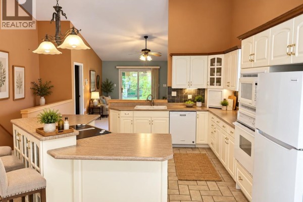 Kitchen with cream cabinets, stainless steel appliances, and a center island. - 1615 Blue Heron, Windsor