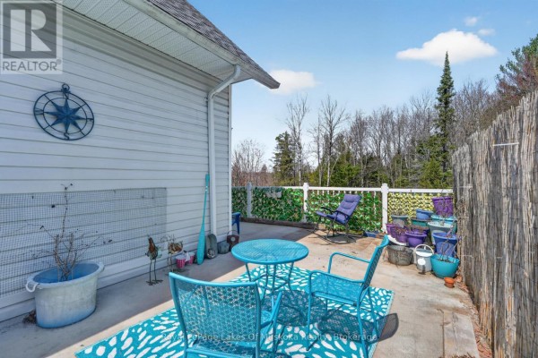 Blue patio set and potted plants on concrete patio with bamboo screen - 1616 Skyline Drive Huntsville