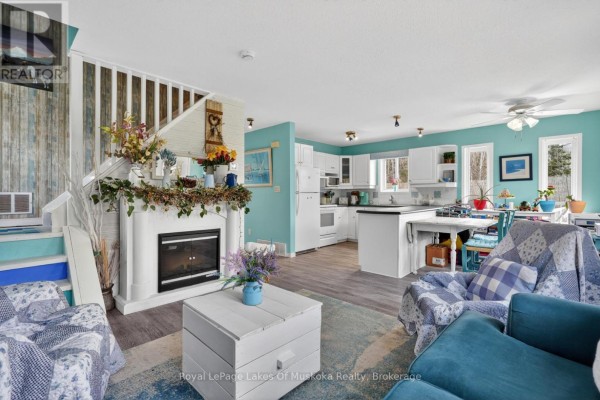Living room with fireplace, white kitchen, and dining area with blue walls and white cabinets. - 1616 Skyline Drive, Huntsville