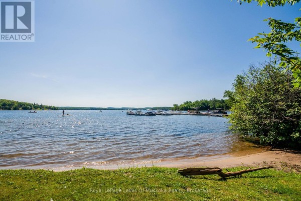 Lakefront with dock, boats, paddleboarder, and sandy beach - 1616 Skyline Drive Huntsville