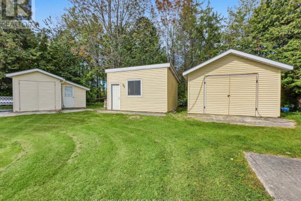 Three detached outbuildings: a small garage, a shed, and a double garage. - 1619 Centreville Road, Stone Mills
