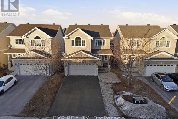 Aerial view of a beige townhouse with a double garage, asphalt driveway, and neighboring homes. - 162 Bert Hall Street, Arnprior