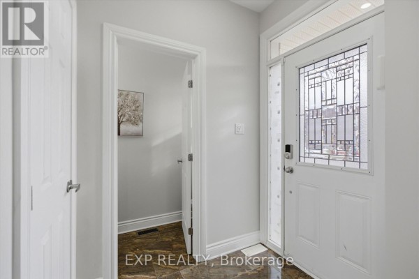 Interior view of a bright entryway with a white front door, sidelight, and a doorway to a powder room. - 162 Bert Hall Street, Arnprior