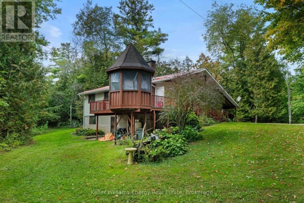 Side view of the house featuring a hexagonal wooden sunroom with a peaked roof. - 162 Jones Road, Cramahe