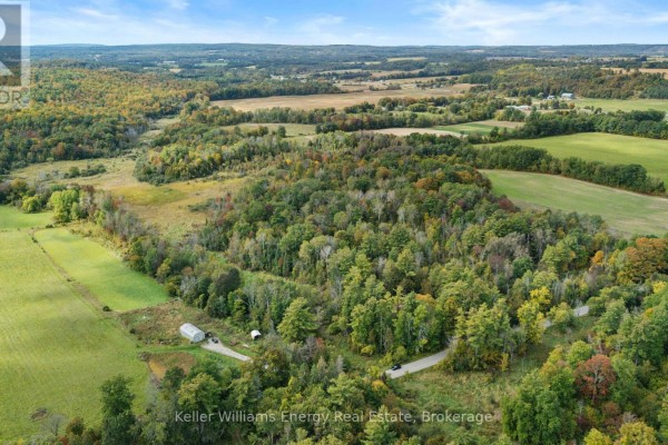 Aerial view of the rural property showcasing fields, trees, and a winding road. - 162 Jones Road, Cramahe