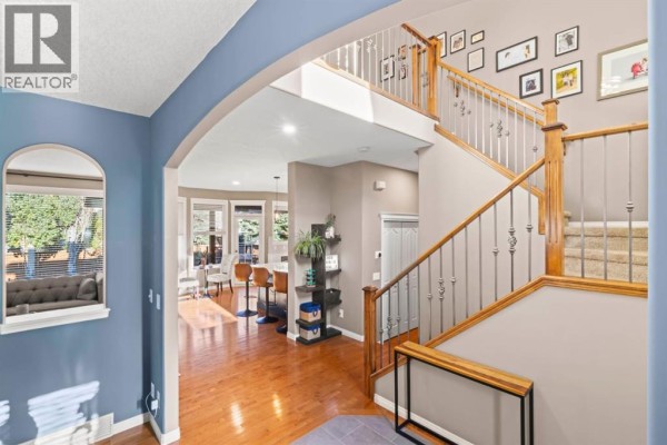 View from the foyer into an open concept living area with a breakfast bar, kitchen, and a staircase. - 1621 Strathcona Drive Sw, Calgary
