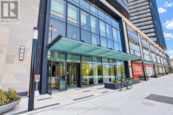 Entrance of a modern apartment building with a revolving glass door and signage reading "585". - 1622 - 585 Bloor Street E, Toronto
