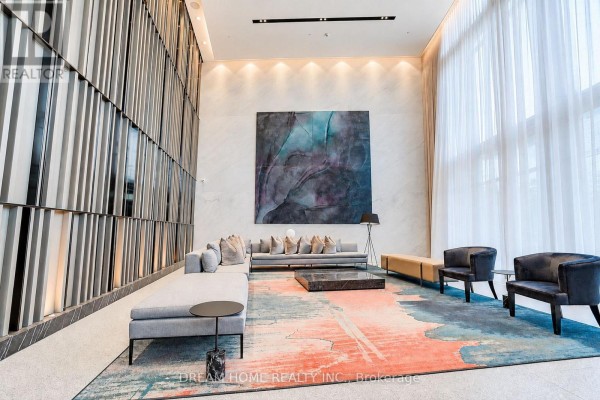 Apartment building lounge area with contemporary furniture, a large abstract rug, and artwork on the wall. - 1622 - 585 Bloor Street E, Toronto