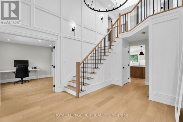 Modern foyer with grand staircase, wainscoting, and office - 163 Confederation Street Halton Hills
