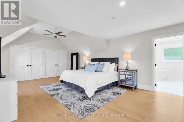 King-size bed, mirrored nightstands, and vaulted ceiling - 163 Confederation Street Halton Hills