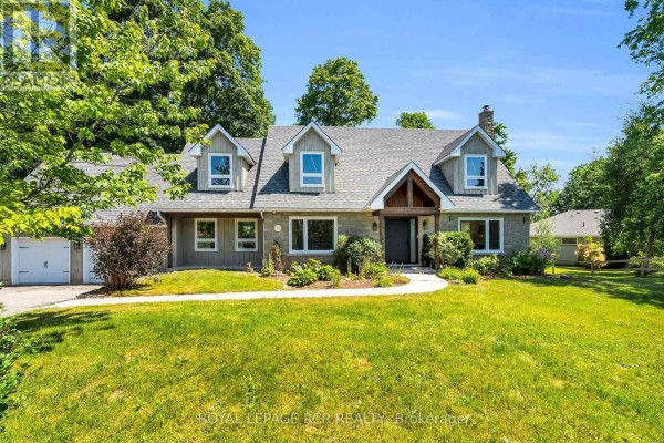 Front view of a house with stone and wood siding, a pitched roof, and a well-maintained lawn. - 163 Confederation Street, Halton Hills