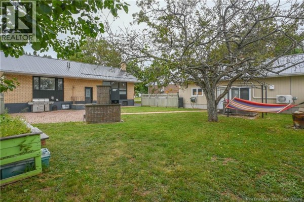 Kitchen with black cabinets, stainless steel appliances, and a round dining table. - 163 Des Peupliers Street, Shippagan