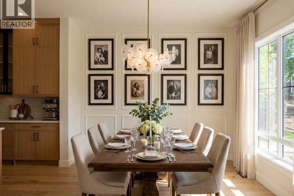 Dining area with light wood floors and large windows overlooking a street. - 1632 21 Avenue Nw, Calgary