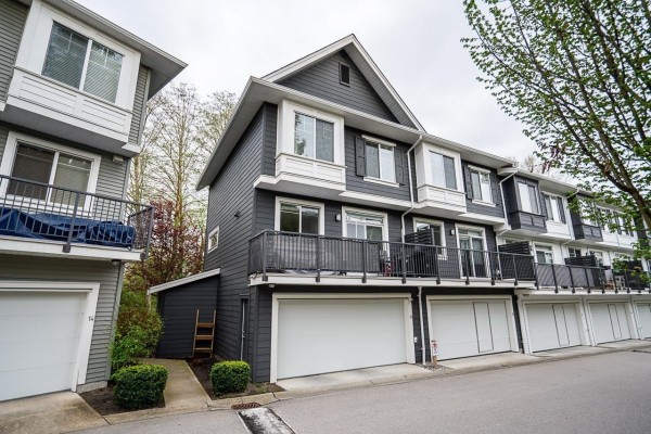 Exterior of dark grey townhouses with white trim, balconies, and garages. - 16337 15 Avenue, Surrey
