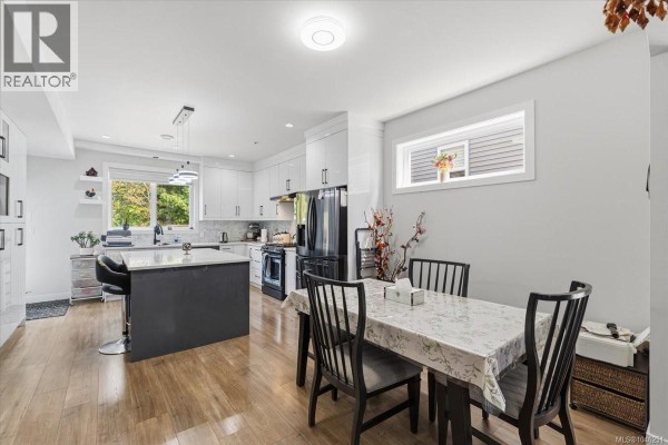 Open concept dining and kitchen area with a table, chairs, and island. - 1636 Roberta Rd S, Nanaimo