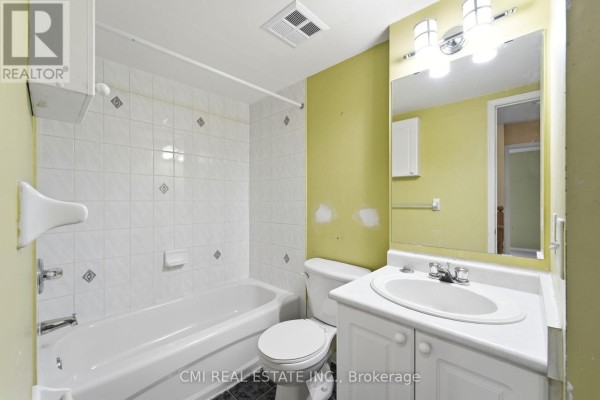 Bathroom with white tiled walls around the bathtub, a white toilet, sink, and vanity. - 164 - 760 Lawrence Avenue W, Toronto