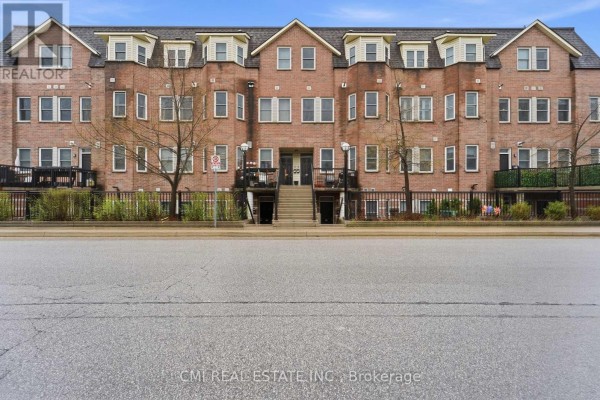 Exterior view of a brick townhouse building with multiple levels and dormer windows. - 164 - 760 Lawrence Avenue W, Toronto