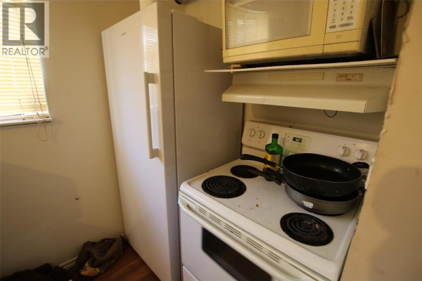 Small kitchen with a white refrigerator, stove, and microwave. - 164 Bergeron Drive, Tumbler Ridge