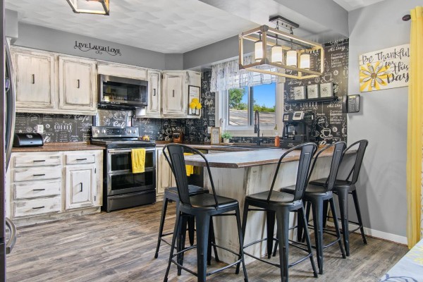 Kitchen with a central island, black bar stools, and white distressed cabinets. - 164 Ch. Fortin, Mansfield Et Pontefract