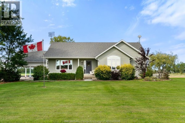 Front view of the house with manicured lawn, porch, and entryway. - 1642 Road 2 West, Kingsville