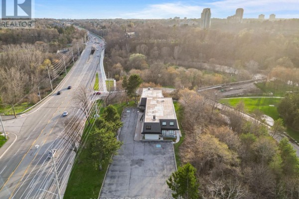 View of the commercial building from above, adjacent to a busy highway and parkland. - 1645 Dundas Street W, Mississauga